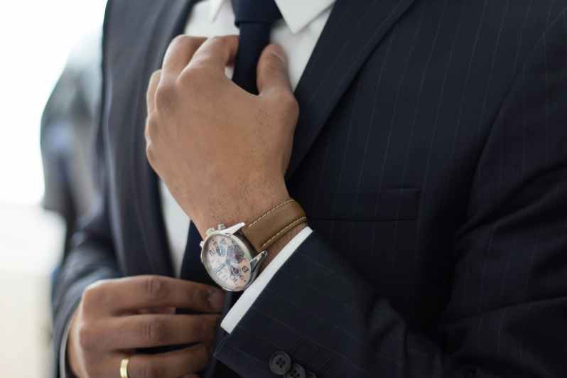 Man adjusting his tie on suit