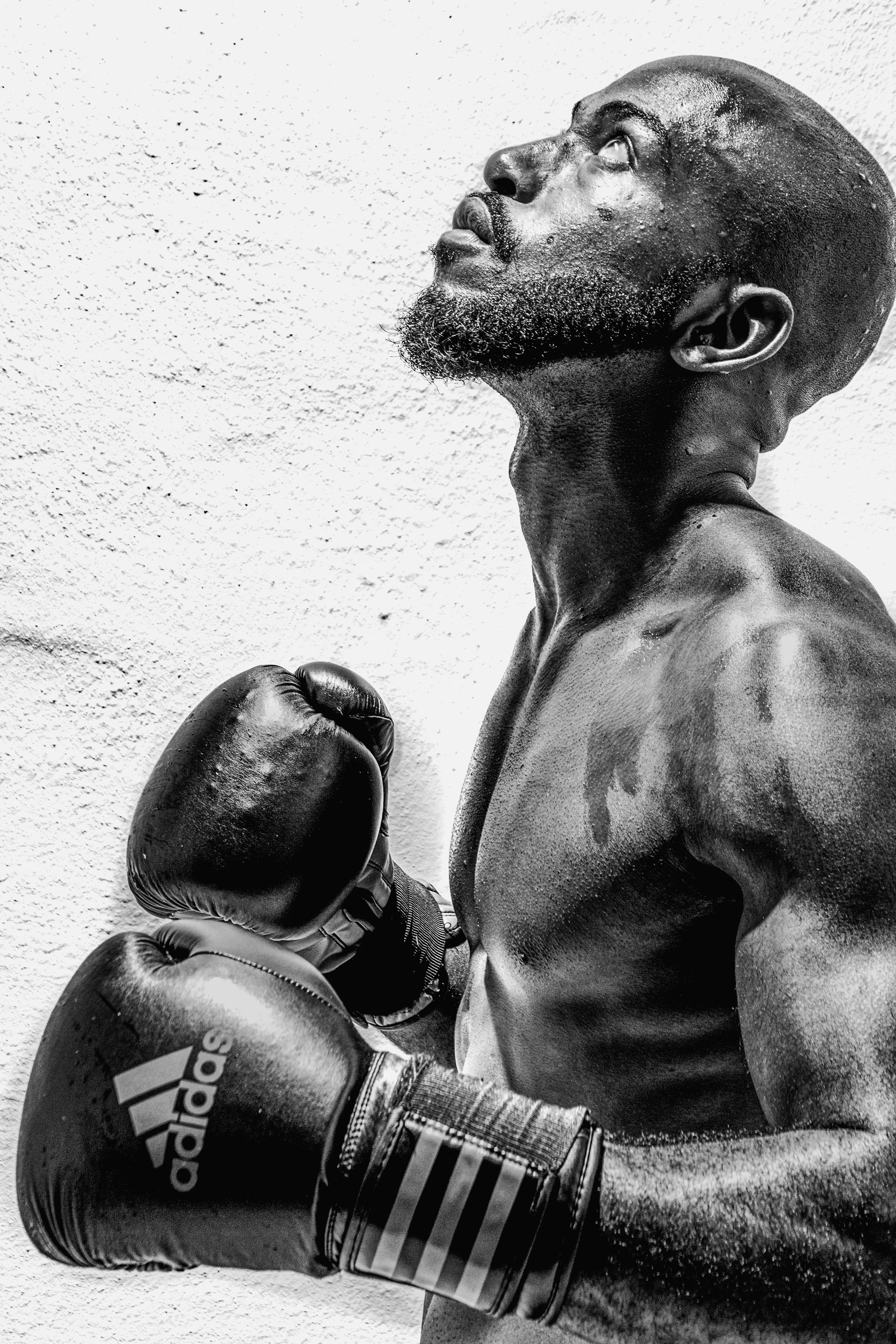 Man wearing boxing gloves close up shirtless looking up